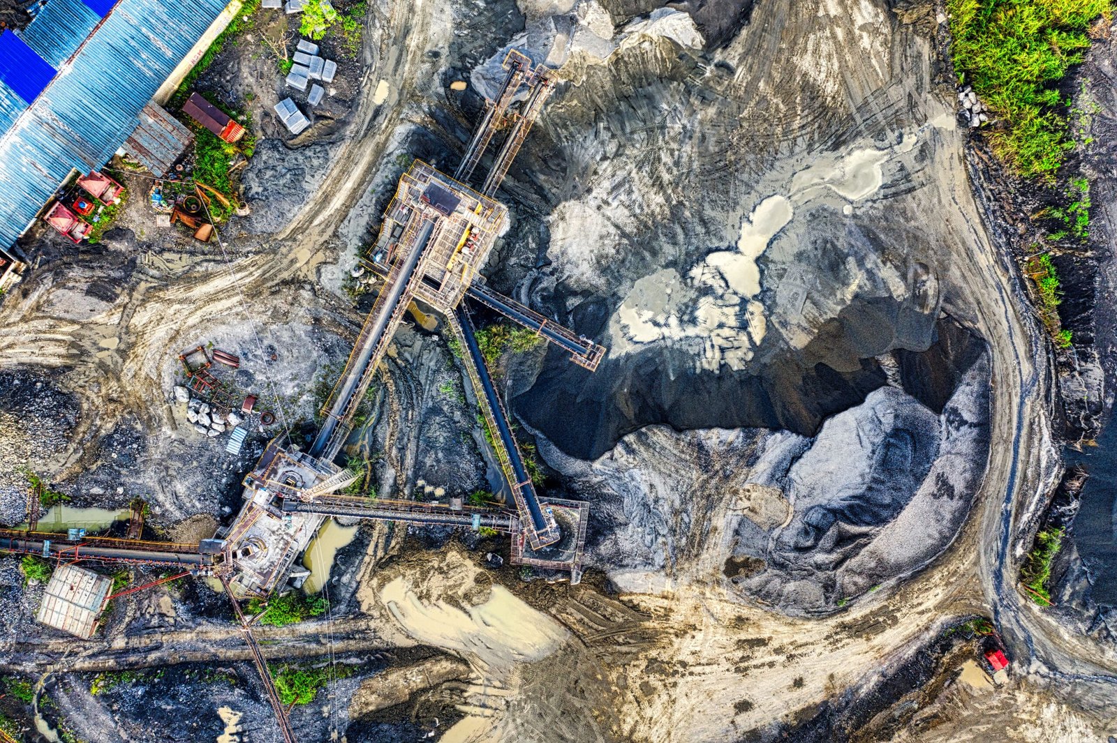 Top-down drone shot of an industrial mining site in Rumpin, West Java, showing machinery and excavation.