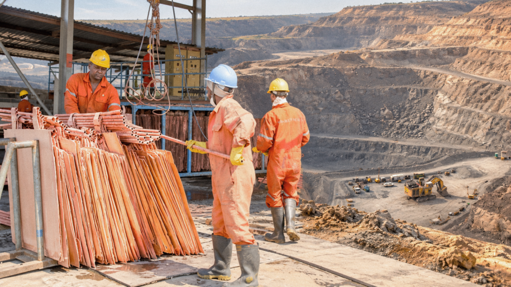 Illustration of workers handling copper beside an open-pit mine.